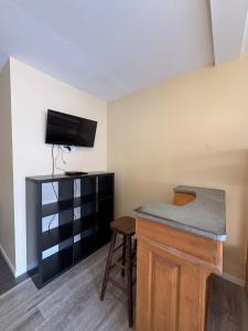 a room with a bar and a tv and a stool at Douglas in Saint Malo