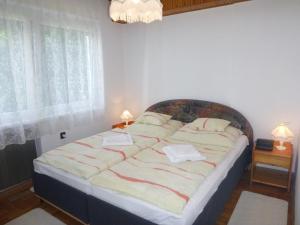 um quarto com uma cama grande e toalhas em Oleander Holiday House em Siófok