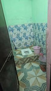 a bathroom with a tile floor with a toilet at Dakshu guest house in Ukhimath