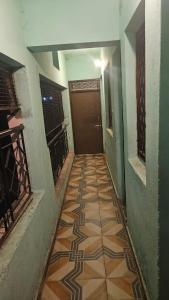 a hallway with a tile floor and a door at Dakshu guest house in Ukhimath +1 photo