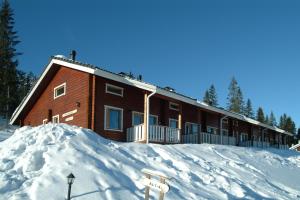 a house in the snow with a pile of snow at Rivitahko 5 in Tahkovuori