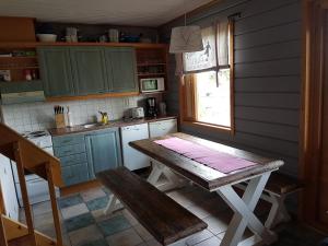 a small kitchen with a wooden table and a window at Rivitahko 5 in Tahkovuori +6 photos