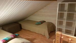 a attic room with a bed and a book shelf at Rivitahko 5 in Tahkovuori