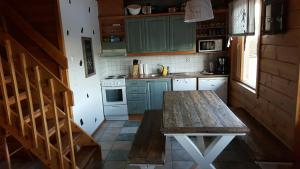 a kitchen with green cabinets and a wooden table at Rivitahko 5 in Tahkovuori