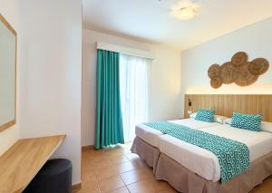 a bedroom with a large bed and a window at Comitas Isla del Aire in Punta Prima +41 photos