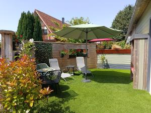 a patio with a table and an umbrella at Les épines in Quend-Plage
