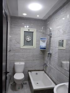 a bathroom with a toilet and a tub and a sink at شقه ارضي بجردين in ‘Ezbet `Abd el-Ḥamîd