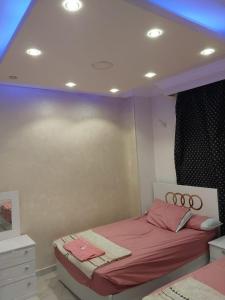 a bedroom with a bed with pink sheets at شقه ارضي بجردين in ‘Ezbet `Abd el-Ḥamîd