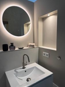 a bathroom with a sink and a round mirror at Alte Schmiede in Sundern