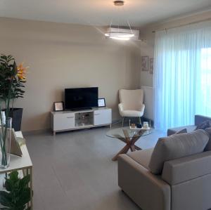 ein Wohnzimmer mit Sofa und Fernseher in der Unterkunft Rea Harmony in Kalamata