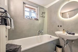 a bathroom with a sink and a bath tub and a sink at Ferienwohnung Lea La Milan in Stockach