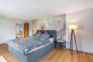 a bedroom with a blue bed with a painting on the wall at Ferienwohnung Lea La Milan in Stockach