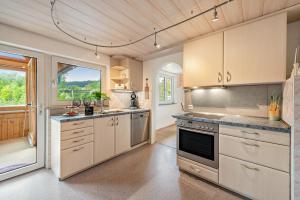 a kitchen with white cabinets and a large window at Ferienwohnung Lea La Milan in Stockach +18 photos