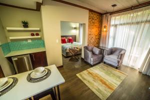 a living room with a kitchen and a bedroom at Grey Manor Guesthouse in Potchefstroom