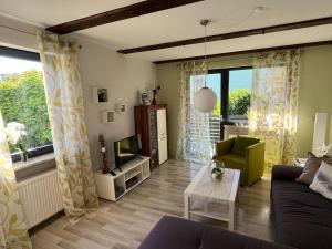 a living room with a couch and a tv at Ferienhaus 1 An der Rodach in Steinwiesen