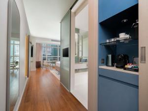 a kitchen with blue walls and wooden floors and a hallway at Pullman Bangkok King Power in Bangkok