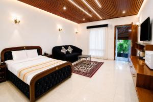 a bedroom with a bed and a couch at Anand Resort - A luxury Private Pool Resort in Nashik in Nashik