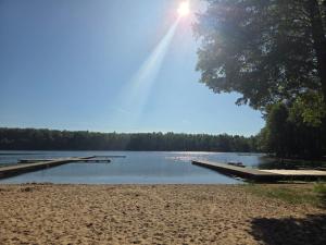 a dock on a lake with the sun in the sky at Domek Przy Jeziorze in Kujanki