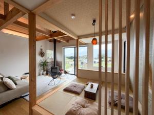 a living room with wooden walls and a large window at Nodokaan Yatsugatake Private Villa in Hokuto