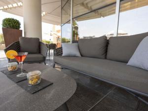 a living room with a couch and a table at Novotel Salerno Est Arechi in Salerno