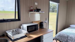 a kitchen with a microwave on a wooden desk at Oscars Retreat 1 by Tiny Away in Raworth
