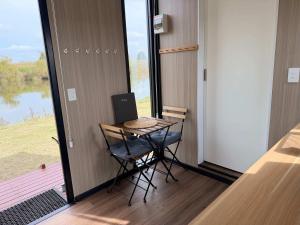 a small table and chair in a room with a window at Oscars Retreat 1 by Tiny Away in Raworth +20 photos