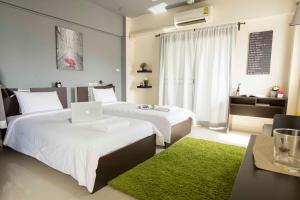 a bedroom with two beds with a laptop on it at A18 in Nonthaburi