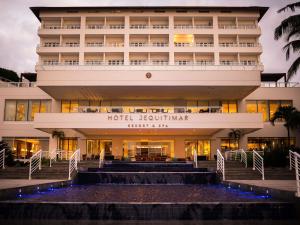 a hotel building with a fountain in front of it at Hotel Jequitimar Guaruja Resort & Spa by Accor in Guarujá
