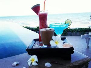 a tray with a drink and some white flowers at Nern Chalet Beachfront Hotel in Hua Hin