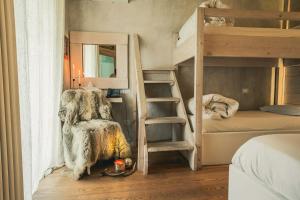 Ein Zimmer mit zwei Etagenbetten und einem Stuhl neben einem Fenster in der Unterkunft Cà Virò - B&B sul Sentiero Valtellina in Albosaggia