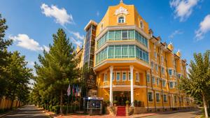 a yellow building with a clock on top of it at Retro Palace Residence Tashkent in Toshkent-Passajir Bekati