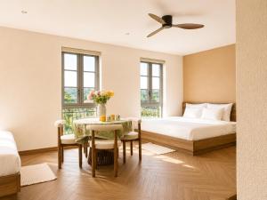 a bedroom with a bed and a table with flowers on it at Vistalago Hotel Khem Beach Phu Quoc in Phú Quốc