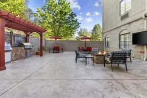 a patio with tables and chairs and a grill at Hampton Inn Salem in Salem