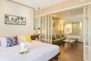 a bedroom with a bed and a living room at Katathani Phuket Beach Resort - SHA Extra Plus in Kata Beach
