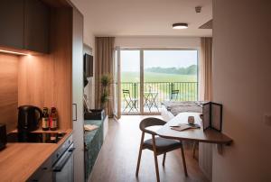 a living room with a table and a kitchen with a view at Hotel Wirt Weissau in Oberweißau