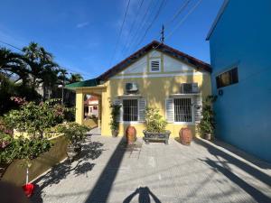 a yellow and white house with plants in front of it at Bắp Bơ Homestay in Cồn Giả Viên