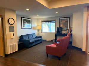 a living room with a couch and chairs and a clock at Comfort Inn Iron Mountain North in Iron Mountain