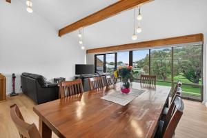 a dining room with a large wooden table and chairs at 4 1 Harbour View Terrace BYO Linen in Victor Harbor