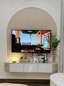 a living room with a large tv on a wall at Lumi Homestay in Phú Thú