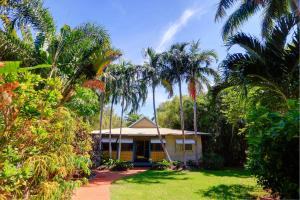 a house in the middle of a jungle with palm trees at Habitat Resort in Broome