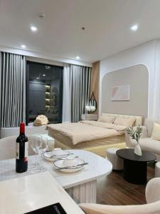 a living room with a couch and a table with a bottle of wine at Lumi Homestay in Phú Thú