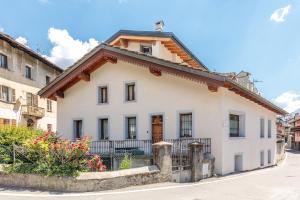 a white house with a brown roof at Maison Jaccod Apartments in Morgex