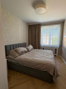 a bedroom with a bed and a large window at Apartament nad jeziorem Rosnowo in Rosnowo