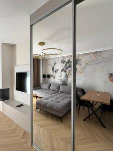 a living room with a couch and a table at Apartament nad jeziorem Rosnowo in Rosnowo