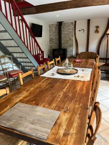 a dining room with a wooden table and chairs at le tilleul in Caumont