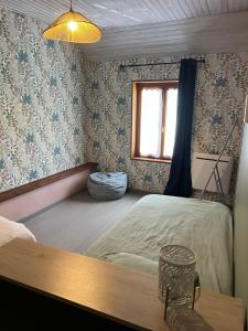 a bedroom with a bed and a window at le tilleul in Caumont