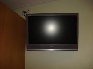 a flat screen tv hanging on a wall at Hotel Gasthof Kreuz in Welschenrohr