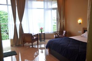 a bedroom with a bed and a large window at The Capitol Homestay in Pīrmed