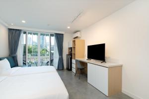 a bedroom with a bed and a desk with a television at Mac's House in Bangkok