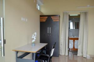 a table and chairs in a room with a door at The Capitol Homestay in Pīrmed